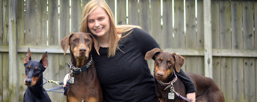 Shelley Belknap and her Dobermans Diesel, Pippa, and Scarlett